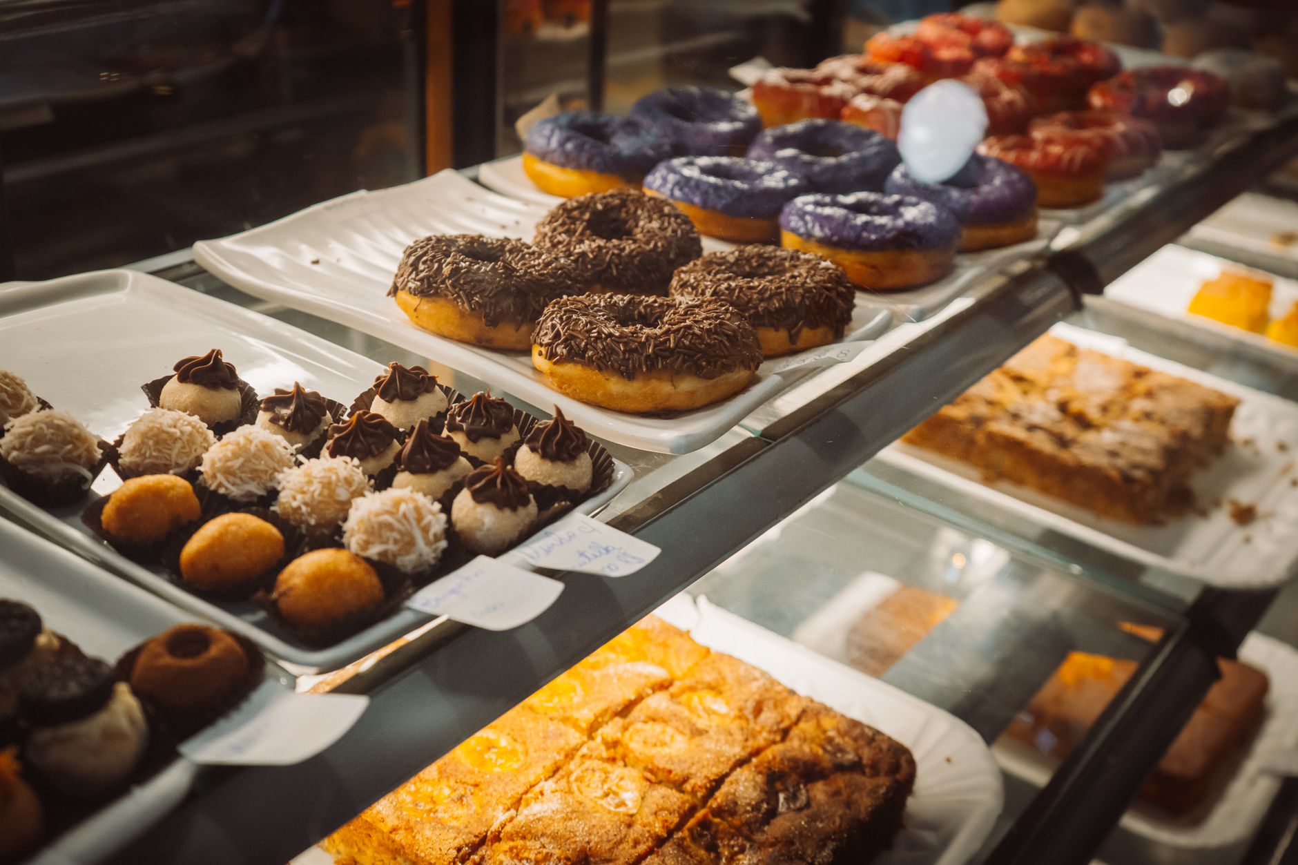 店のショーケースに並ぶ色とりどりのドーナツ